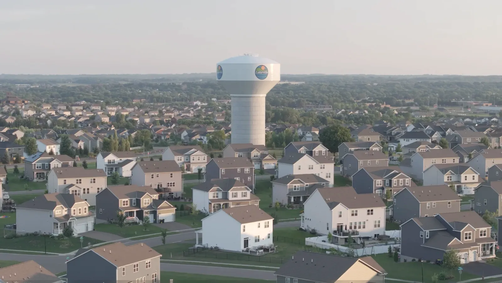 Aerial view of a Lakeville, Minnesota neighborhood in the south metro with homes and a water tower at golden hour